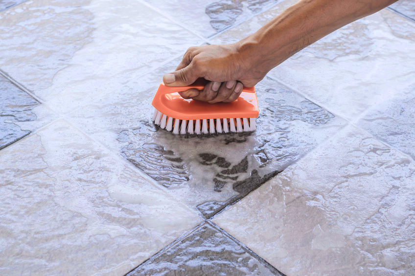 Man scrubbing tile floor